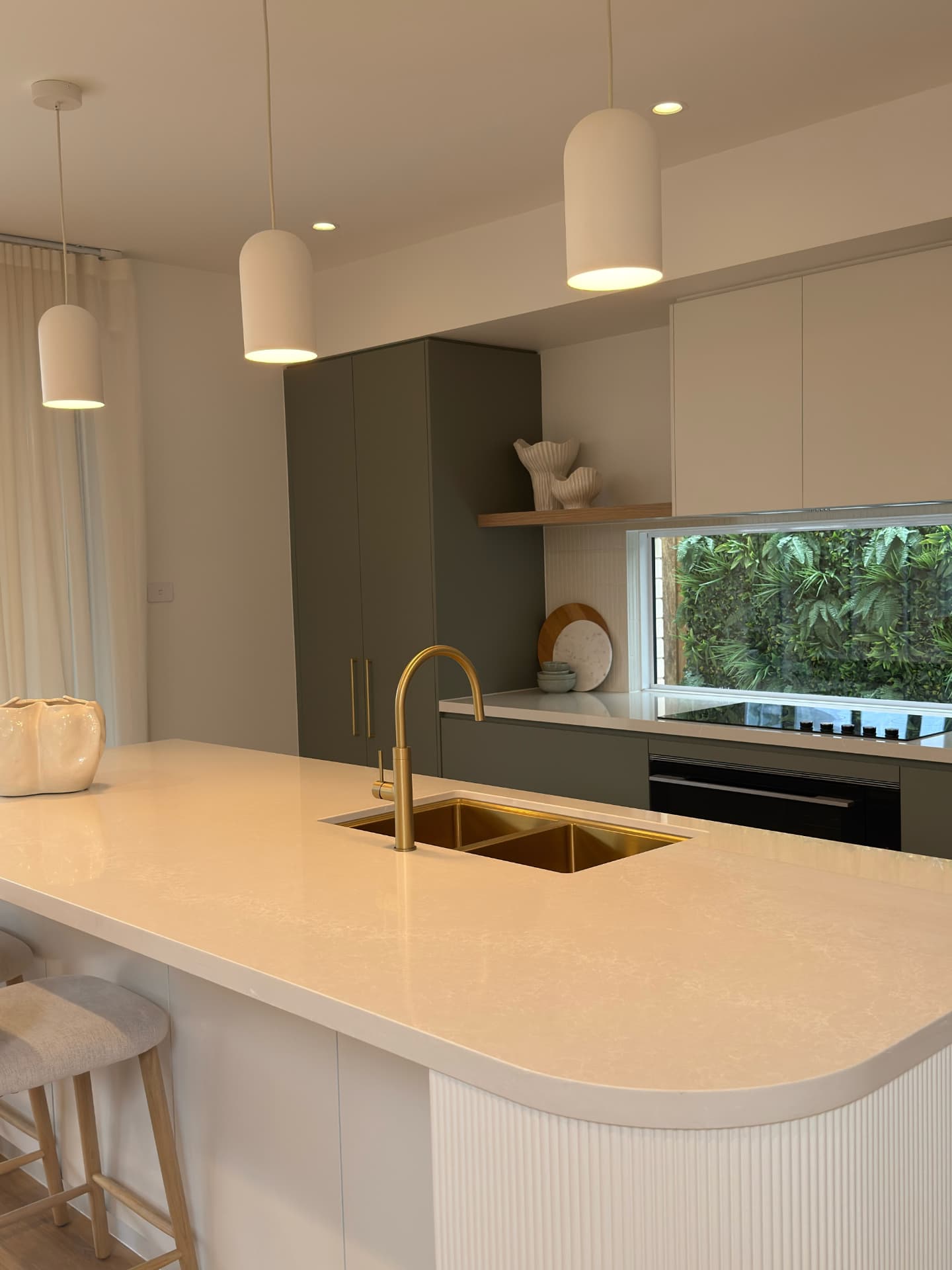 Kitchen with a stone island, gold tap and freshly presented cabinetry